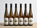 six bouteilles de vin sont alignées sur une table en bois
