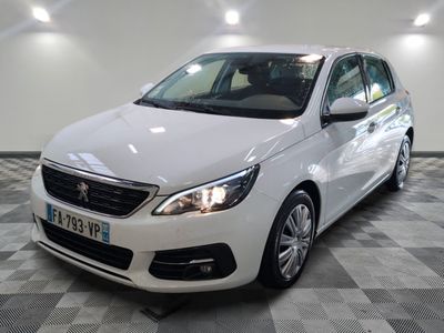 la voiture blanche est garée sur un sol en damier dans le garage