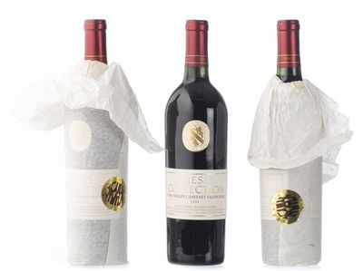 trois bouteilles de vin sont emballées dans des sacs en plastique, posées sur une surface blanche