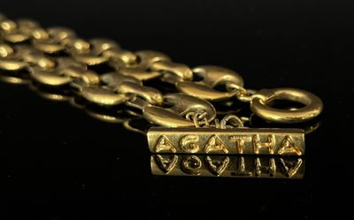 an image of a close up of a gold necklace on a black surface