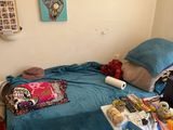 a small bed in a small room with a blue comforter