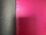 the back of a pink and black laptop computer sitting on top of a table