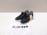 navy blue sneakers with white soles and a t - shirt on a white table