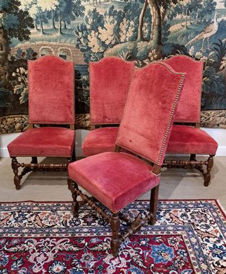 deux chaises rouges et un tapis rouge devant une tapisserie