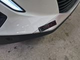 a close up of the front bumper of a white car