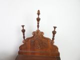 a wooden bed with two candles on top of it