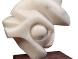 sculpture en marbre représentant un coquillage, posée sur un socle en bois, sur fond blanc