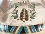 a silver vase with a blue and yellow design on it
