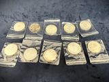 several gold coins are in plastic bags on a black surface