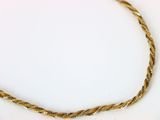 une photo d'un collier en or posé sur une assiette blanche