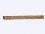 a close up of a metal bracelet on a white surface