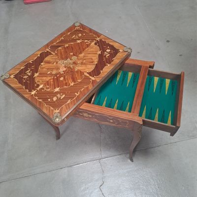 une table en bois sur laquelle se trouvent un plateau de jeu et un tiroir