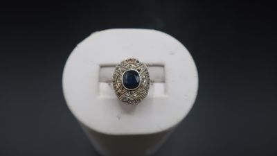 a close up of a ring with a blue stone in it