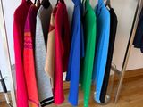 a lot of clothes hanging on a rack in a room
