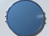 a round mirror hanging on the side of a white wall