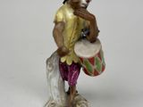 a figurine of a man with a drum and a hat
