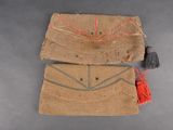 two pieces of cloth with tassels on a gray surface