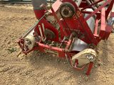 une machine rouge qui est à l'arrêt dans la poussière