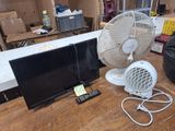 un ventilateur et un téléviseur posés sur une table dans une pièce