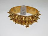 un gros plan sur un bracelet en or orné de pointes