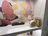 a bathroom with a sink and a shelf with a lot of items on it