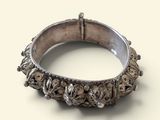 une image montrant un gros plan d'une bague en argent posée sur une surface blanche