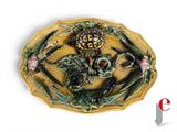 a decorative plate with a skull and two birds on it