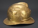 brass fire helmet on a gray background