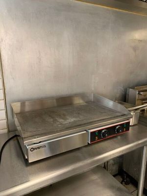 plan de travail en acier inoxydable dans une cuisine professionnelle équipée d'une plaque de cuisson électrique