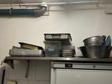 a white refrigerator in a kitchen with a lot of pots and pans on top of it