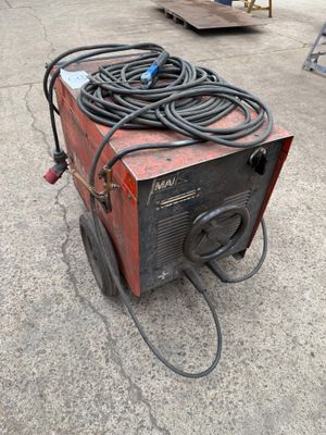 an image of a welding machine sitting on top of a cement floor