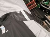 a black and white jacket laying on top of a bed