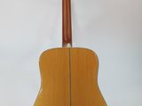 an acoustic guitar on a stand against a white background