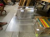 table en acrylique transparent avec quatre étagères et une paire de chaussures