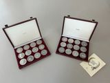 two silver coins are in a wooden case on a table