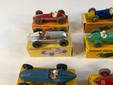 several toy cars are lined up in a row on a white surface