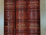 four old leather books sitting on top of a wooden table