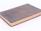 an old book is sitting on a white surface
