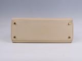 beige leather purse with rivets and rivets on the front