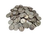 a pile of old silver coins on a white surface