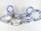 blue and white china dishes and cups are arranged on a white surface