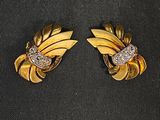 une paire de boucles d'oreilles en or et diamants sur une surface noire