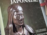 un livre surmonté d'une statue représentant une femme