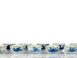 Plusieurs bols et tasses bleus et blancs sont alignés sur une table