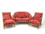 un canapé rouge et deux fauteuils à pois