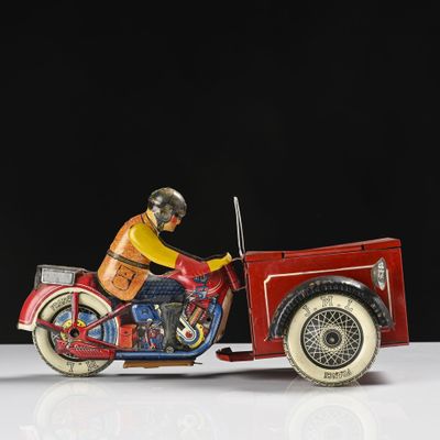 une moto jouet rouge avec un homme dessus