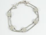 a close up of a silver bracelet on a white background