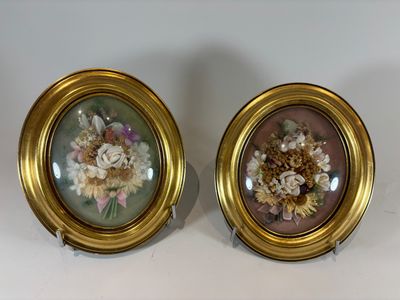pair of gold framed floral paintings on a white background