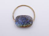 a close up of a gold ring with a blue stone on it