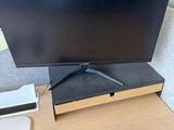 La télévision à écran plat est posée sur le bureau, à côté d'une télécommande.